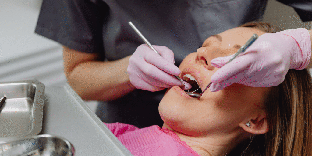 Patient nervously sitting in dental chair while dentist gently examines teeth, illustrating overcoming dental anxiety.