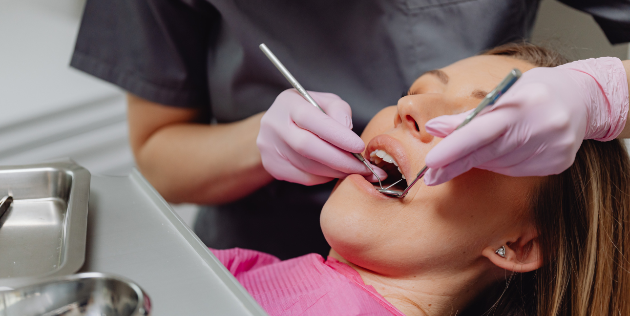 Patient nervously sitting in dental chair while dentist gently examines teeth, illustrating overcoming dental anxiety.